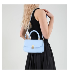 Detail view of light blue leather handbag with gold twist lock and adjustable strap