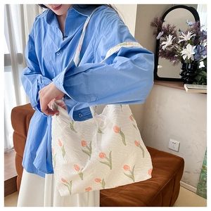 Detail of floral tote bag with orange tulips, pleated fabric and pearl chain strap