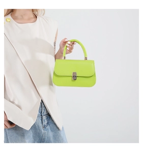 Dettaglio borsa a tracolla verde neon con manico rotondo e chiusura a girello in metallo