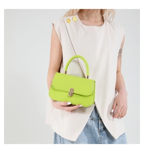 Dettaglio mini borsa verde fluo con chiusura in metallo dorato e manico superiore