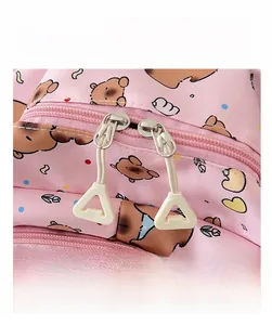 Close-up of pink cartoon bear backpack showing smooth dual zippers and white pulls