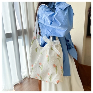 Detail of floral tote bag with lace bow, pearl charm and textured tulip print fabric