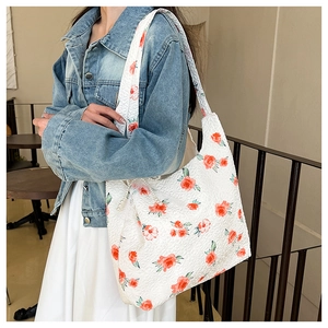 Detail of floral tote bag with rose print, textured fabric and elegant pearl chain strap