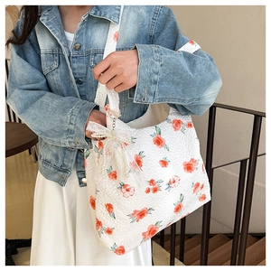 Close-up of floral jacquard tote bag with lace bow and pearl pendant details