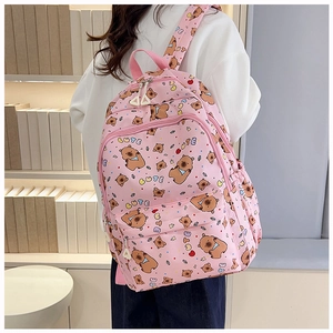 Close-up of pink backpack featuring cute cartoon bear patterns and CUTE letter prints