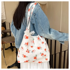 Detailed close-up of a white tote bag with pink rose floral print and pearl lace bow