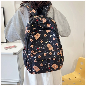 Close-up of black backpack with cute cartoon bear and colorful CUTE letter prints