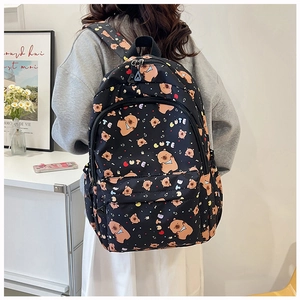 Close-up of black backpack with cute brown bear prints and colorful CUTE lettering