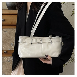 Detail of a creamy white rectangular underarm bag with silver buckle on wooden background