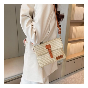 Detailed macro of woven straw texture with adjustable brown leather strap and brand name tag