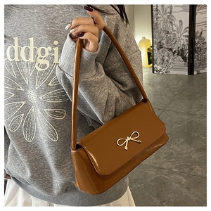 Gros plan d'un sac baguette marron vintage avec une boucle dorée en forme de nœud