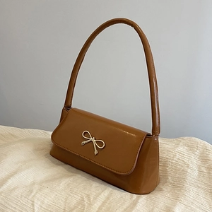 Vue détaillée du sac porté épaule en similicuir marron avec boucle nœud dorée