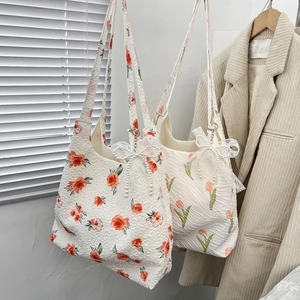 Floral print tote bags with textured fabric and pearl bow charms in a cozy home setting