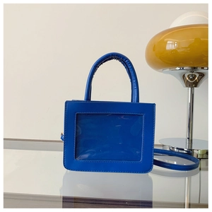 Detail of royal blue PVC handbag with transparent window and adjustable strap