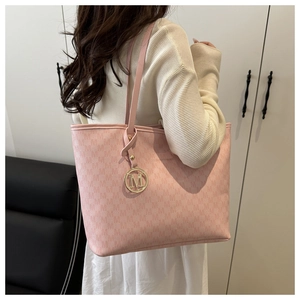 Detail of pink tote bag with M-pattern jacquard and gold metal brand charm accessory