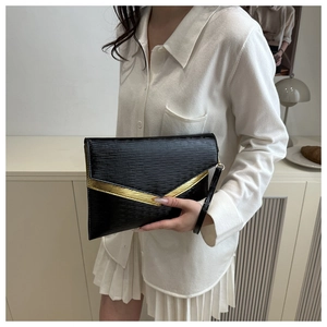 Dettaglio pochette a busta nera con trama a onde, decorazione a V dorata e cinturino da polso