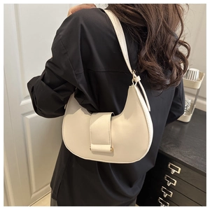 Chic cream crescent shoulder bag with gold buckle shown on a model in a modern interior