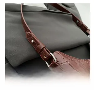 Detail der braunen Krokodil-Handtasche mit silbernen Beschlägen und Trageriemen