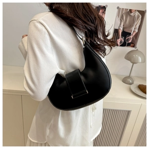 Detail of minimalist black crescent bag with sleek belt buckle and gold metal hardware