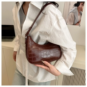 Detail der braunen Hobo-Tasche mit Krokoprägung, silberner Schleife und verstellbarem Gurt