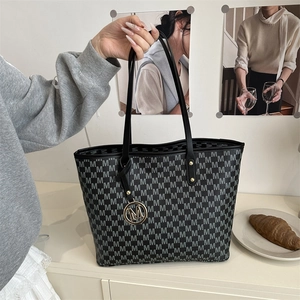 Black tote bag with M-letter monogram print and golden metal pendant detail