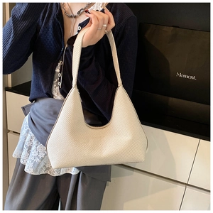 Detail of a beige woven hobo shoulder bag featuring a stylish crescent-shaped design