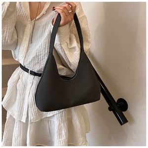 Détail du sac hobo noir en tissu texturé avec bandoulière structurée et fini élégant