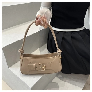 Detail of beige faux leather handbag with metal buckle and knotted shoulder strap