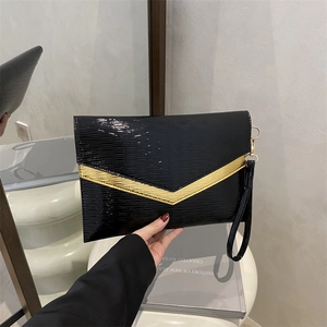 Chic black glossy envelope clutch bag with gold V-metal trim and leather wrist strap