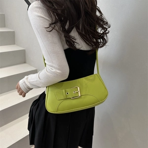 Chic lime green underarm bag with gold metal buckle shown on model in a minimalist setting