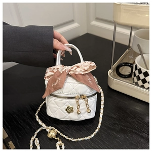 Detail of white quilted mini bag featuring gold camellia charm and leopard silk scarf