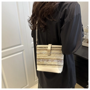 Detail of woven patchwork bucket bag featuring vintage metal twist lock and leather strap