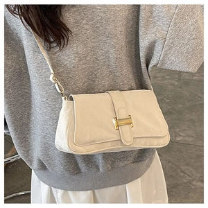 Detailed view of off-white baguette bag featuring golden H buckle and leather texture