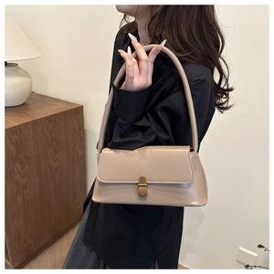 Detail of beige rectangular crossbody bag with vintage gold metal lock and stitching