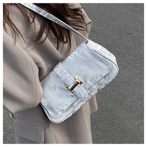 Detail of light grey pleated leather baguette bag with signature gold H-clasp
