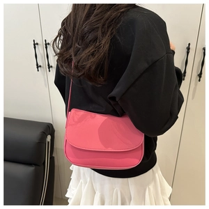 Pink leather saddle bag worn by model showing trendy minimalist shoulder carry style