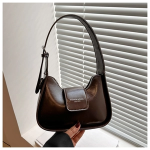 Close-up of retro dark brown leather shoulder bag with magnetic flap and metal zipper