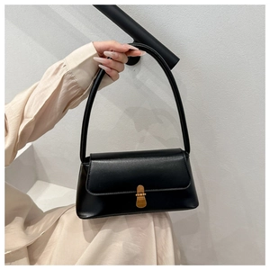Detail of minimalist black leather handbag with premium vintage gold metal buckle closure