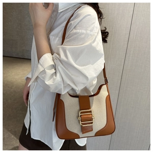 Gros plan d'un sac sous les bras vintage en toile avec garniture en cuir et boucle dorée