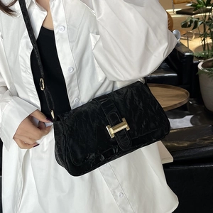 Elegant black pleated leather baguette bag with a gold H-clasp and adjustable strap