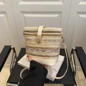 Fashionable woven bucket bag with cream leather trim and gold twist lock in an elegant setting