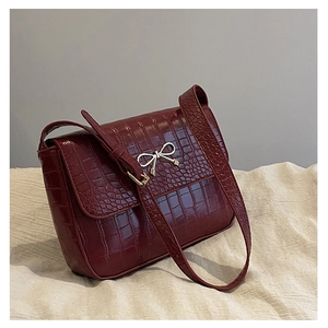 Détail du sac en cuir crocodile bordeaux avec boucle en métal noeud argenté