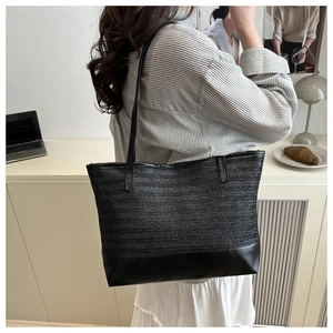 Détail du sac cabas tissé noir avec texture en chevrons et base en cuir synthétique mat