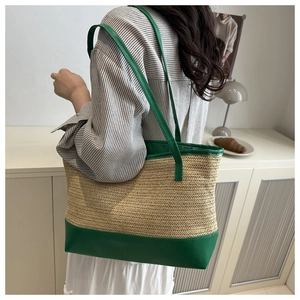 Detalle de la correa de cuero verde y textura de paja tejida en bolso tote de playa