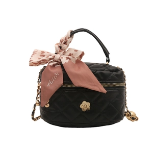 Quilted black bucket bag with gold floral clasp and silk scarf handle detail