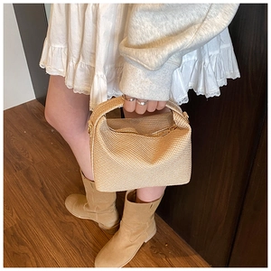 Vue de dessus d'un sac à main beige tissé avec anse assortie et robe d'été blanche