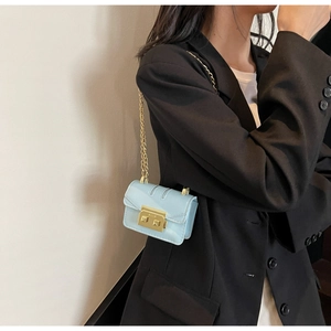 Détail du mini sac en cuir verni bleu clair avec chaîne dorée et fermoir métal