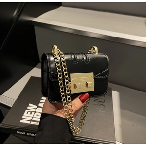 Détail du sac à main noir plissé avec fermoir carré doré et bandoulière en chaîne