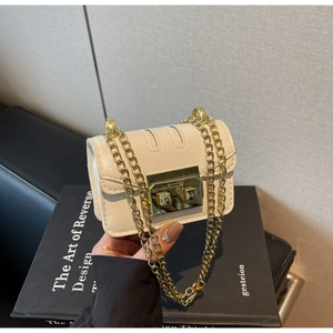 Détail du mini sac bandoulière crème avec chaîne dorée et boucle carrée métallique