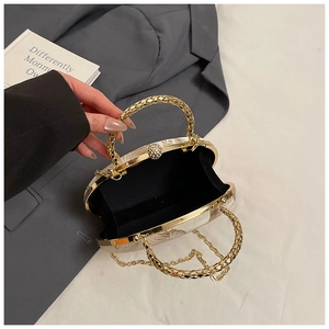 Macro view of champagne gold evening bag showing pearl clasp and chain strap detail